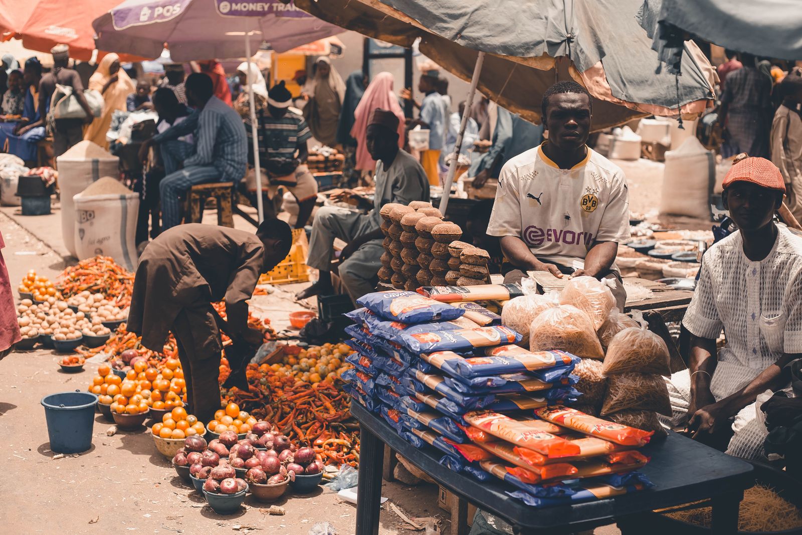 Marche africain anime, etals de produits frais sous parasols