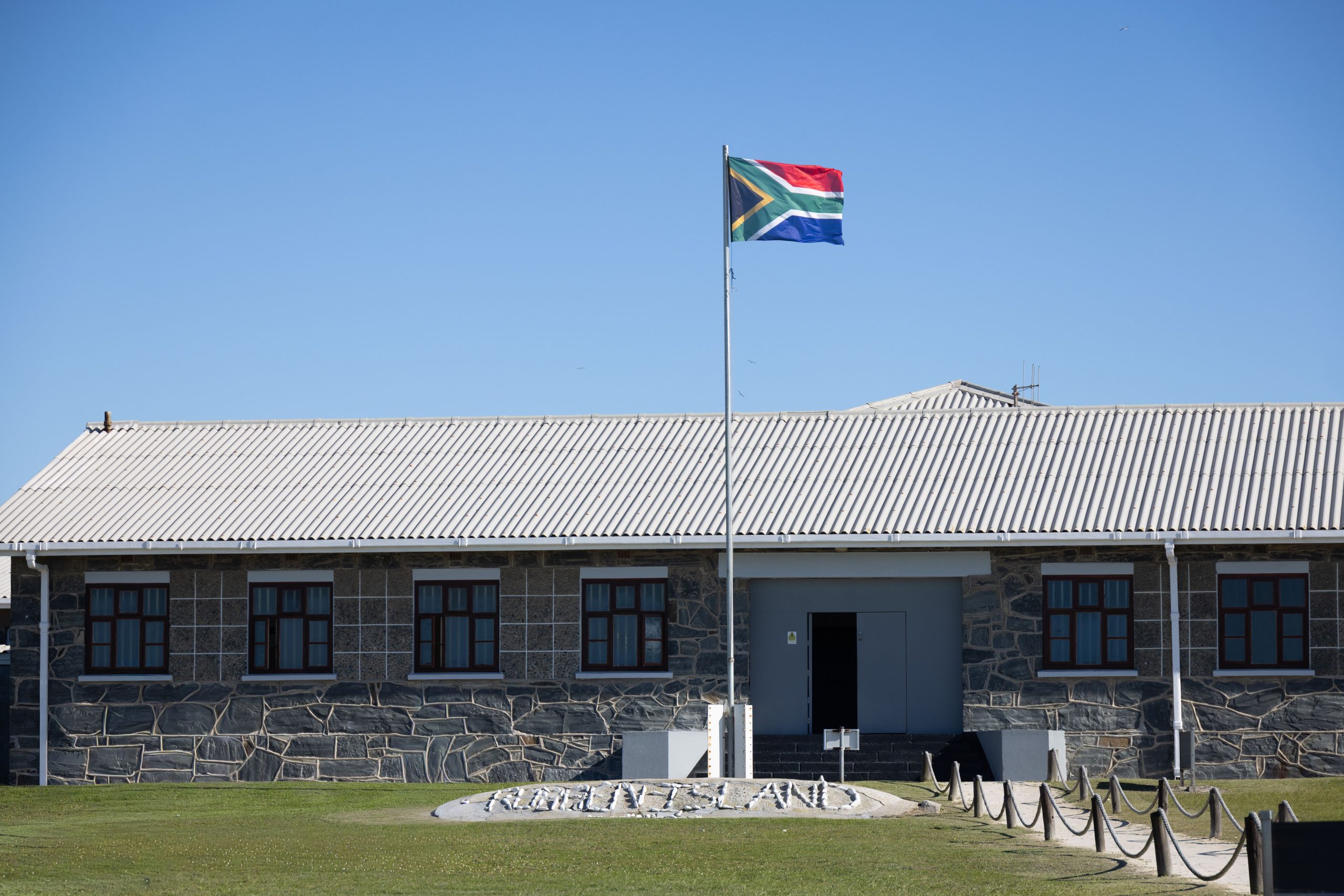 Batiment du musee de Robben Island et drapeau sud-africain